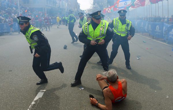 April 15, 2013. Boston police officers react to a second explosion near the finish line of the 117th Boston Marathon. Credit: John Tlumacki - Boston Globe